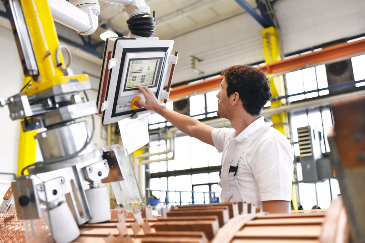 young mechanical engineering workers operate a machine for winding copper wire - manufacture of transformers in a factory